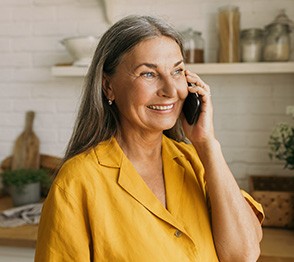 Woman smiling while talking on phone in kitchen