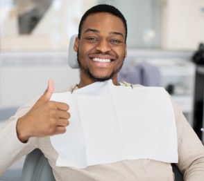 Smiling man giving thumbs up in treatment chair