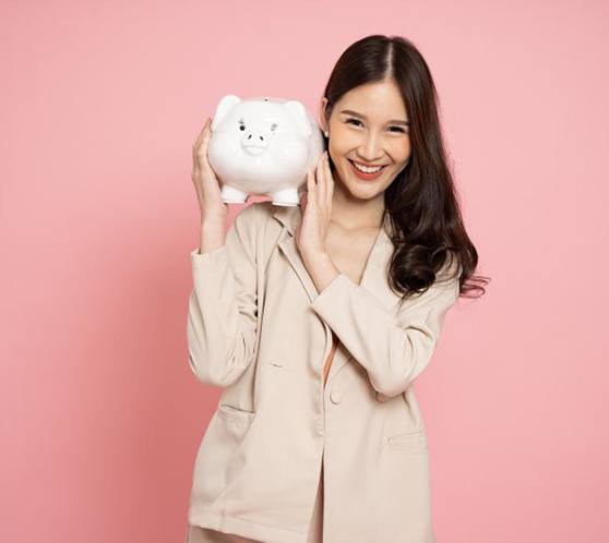 Woman holding a piggy bank and smiling