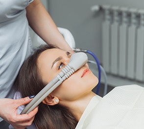 Dental assistant placing nasal mask on patient