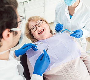 Woman smiling at dentist while relaxing in treatment chair