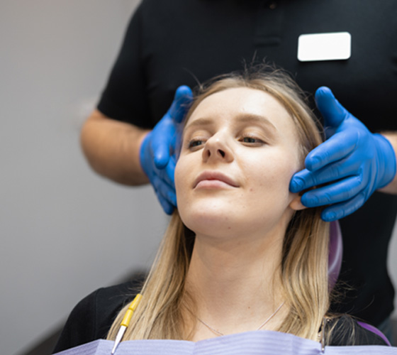a dentist examining a patient’s jaw joints