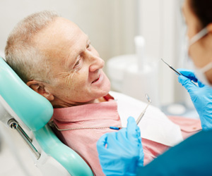 a man sitting in a dental chair having his teeth examined